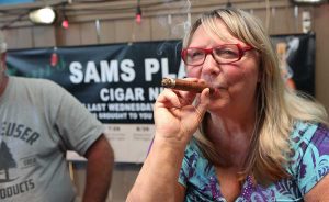 A woman enjoys a cigar at Sam's Place Cigar Night