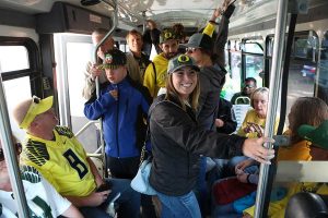 Oregon Duck fans smile adn chat as they wait for Sam's Shuttle to take them to Autzen Stadium for a home game