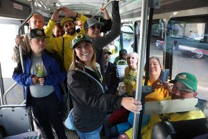 Oregon Duck fans smile adn chat as they wait for Sam's Shuttle to take them to Autzen Stadium for a home game
